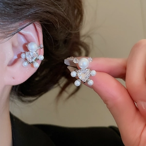 Close-up of pearl and heart zircon bear ear cuff showing elegant jewelry details