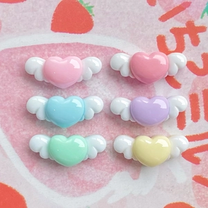 Close-up of colorful resin heart wings charms for DIY phone case and hair accessories