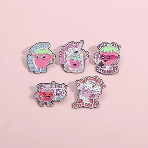 Detail view of five cute enamel strawberry badges with creative puns on pink background