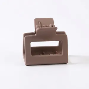 Close-up of matte light brown rectangular claw clip with metal spring opening detail