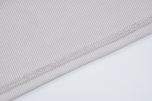 Détail du tissu en maille côtelée gris clair avec une finition de couture surjetée pro