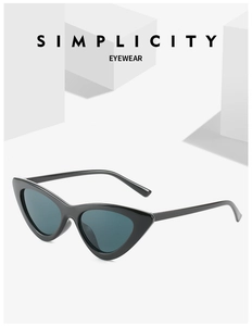 Close-up of stylish black cat eye sunglasses on white geometric blocks with sharp detail