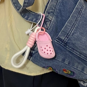Pink mini garden shoe keychain on blue denim bag with white woven rope detail