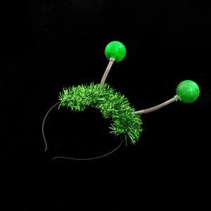 Detail of green alien antenna headband with sparkly glitter balls and tinsel on springs