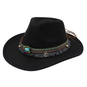 Detail of ethnic hat featuring turquoise ornament, silver coins, and woven tassels