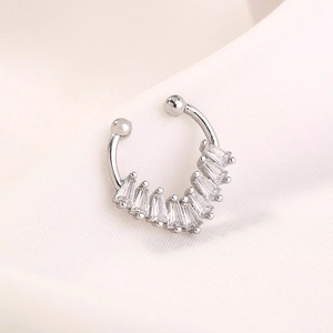 Macro shot of silver horseshoe nose clip with rectangular cubic zirconia stones