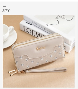 Detail of grey leather long wallet with diamond quilted pattern and double zipper design