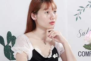 Elegant rose gold leaf necklace and earrings set worn by model in a studio setting