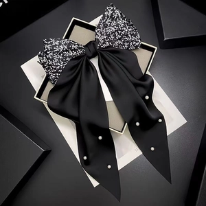 Elegant floral print bow hair clip with black satin ribbons and pearl accents for women