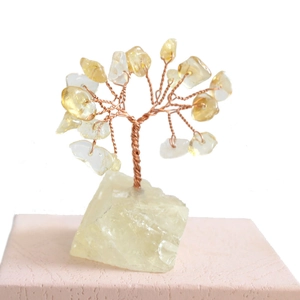 Detailed view of yellow crystal money tree on natural stone base for home decor