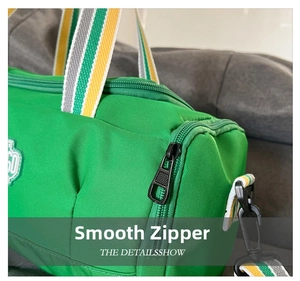 Detail of smooth black zipper and striped strap on green cylinder sports bag
