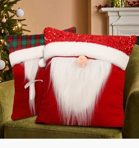 Close-up of Santa gnome Christmas pillows with sequins and plaid on a cozy green sofa