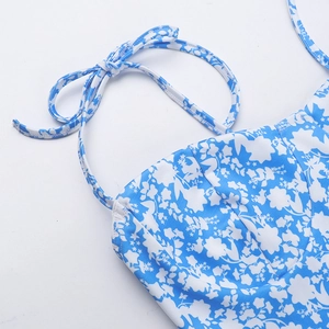 Detailed close-up of blue and white floral dress shoulder straps and fabric stitching