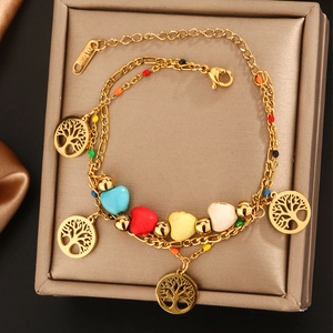 Detail eines 18K vergoldeten zweilagigen Armbands mit Lebensbaum-Anhängern und Perlen