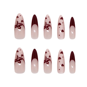 Handmade almond press-on nails with burgundy French tips, hearts, and ribbon bow designs