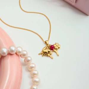 Detailed view of 18K gold stainless steel necklace with elephant and clover charms
