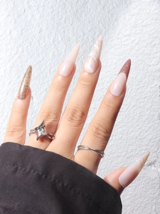 Faux ongles stiletto longs avec texture marbre, paillettes dorées et pointes bordeaux