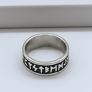 Vue macro d'une bague vintage argentée avec gravure de runes et finition oxydée