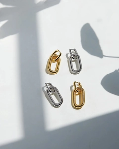 Close-up of minimalist chain link earrings in gold and silver with textured finish