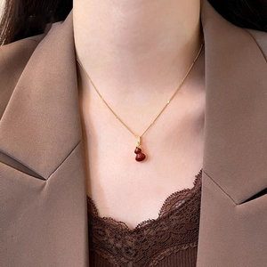 Collier élégant plaqué or avec pendentif gourde rouge pour femme sur mannequin