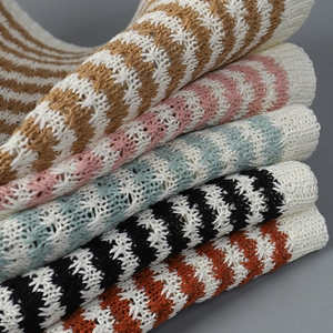 Close-up of stacked colorful striped knit bucket hats showing detailed texture and patterns