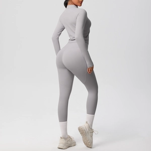 Détail d'un ensemble de yoga gris clair extensible avec veste zippée et legging taille haute
