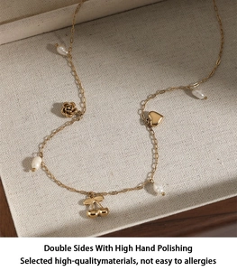 Detail of gold necklace with rose, heart, and cherry charms in a jewelry box