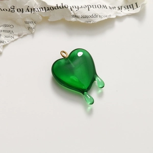 Close-up of a translucent green melting heart pendant with a gold ring attachment