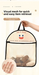 Détail du sac de rangement en filet beige avec visage sourire rouge et poignée noire
