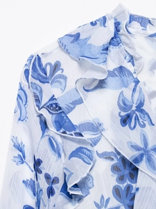 Detailed close-up of blue floral print chiffon fabric with delicate ruffle edge detailing