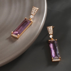 Vue macro des boucles d'oreilles en zircone violette avec monture dorée vintage