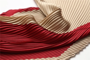 Detailed macro view of pleated silk scarf with luxury red and champagne gold stripes