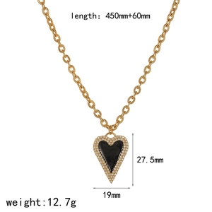 Elegant gold heart necklace with black enamel inlay and sparkling crystals on a pearl chain