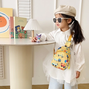 Close-up of a child wearing a yellow cartoon car crossbody bag in a cozy home setting