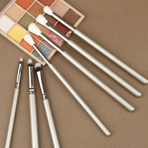 Détail d'un ensemble de 7 pinceaux de maquillage pour yeux aux manches or champagne mats