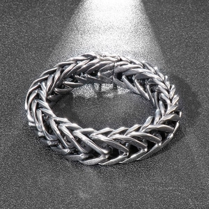 Detailed close-up of chunky V-shaped stainless steel woven chain bracelet for men
