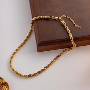 Détail du collier chaîne torsadée dorée montrant le fermoir mousqueton et l'extension