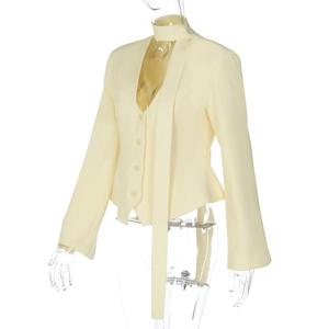 Detail of light yellow slim blazer featuring a unique necktie design and four buttons