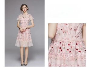 Détail de broderie florale et jupe en tulle sur une robe rose à manches courtes