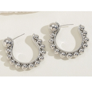 Close-up of silver-toned C-shaped earrings with bead-textured design and 925 silver posts