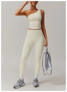 Détail de l'ensemble de yoga crème avec haut à une épaule et legging taille haute à poches