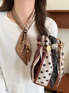 Detail of bohemian silk neck scarf with paisley pattern and golden metal heart buckle