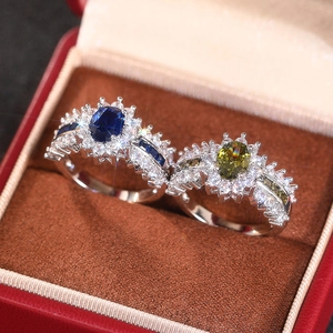 Makroaufnahme von ovalen blauen und grünen Edelsteinen in silbernen Zirkonia-Ringen