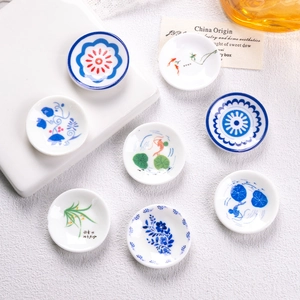 Eight-piece set of miniature blue and white ceramic plates with floral and koi patterns