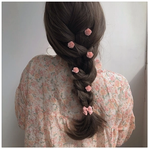 Haarschmuck-Set mit rosa Kamelien-Clips und Schleife an einer Flechtfrisur