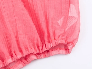 Detail shot of pink bohemian pleated fabric with elastic smocked cuffs and ruffle trim