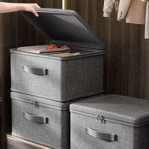 Set of 3 gray fabric storage boxes with lids and handles stacked in a closet