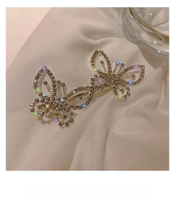 Detailed view of a dual bow hair clip featuring sparkling colorful rhinestones on white silk