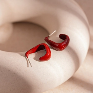 Vue macro de boucles d'oreilles géométriques en émail rouge brillant avec tiges en argent