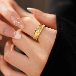 Dettaglio anello a zucca placcato oro con zirconi brillanti su un dito femminile